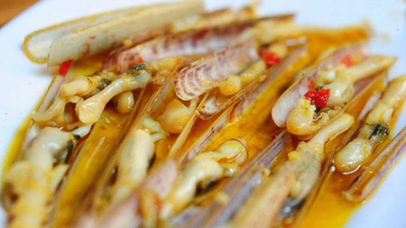 Ốc móng tay xào bơ tỏi với nước sốt vàng óng, rắc thêm chút rau thơm