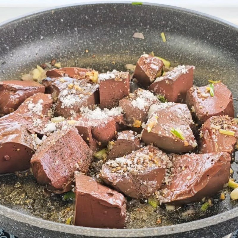 Phi thơm hành tỏi và gốc hẹ trước khi cho huyết vào xào