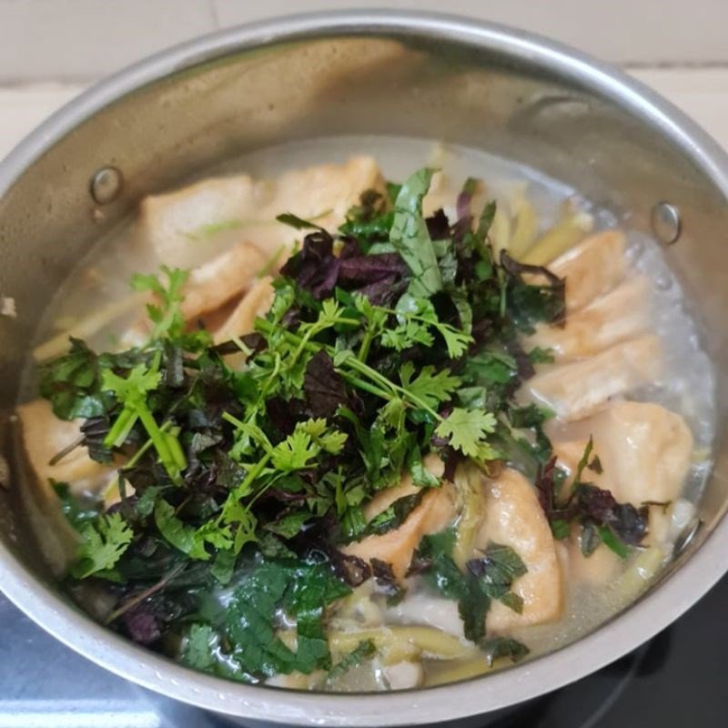 Rắc rau thơm tía tô lên bề mặt canh ngó khoai sau khi nấu