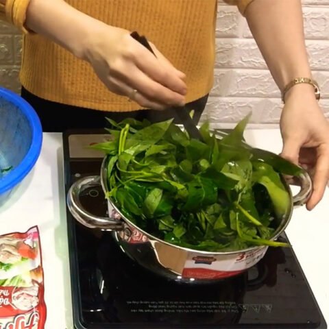 Rau khoai lang tươi xanh đang được sơ chế trên thớt gỗ