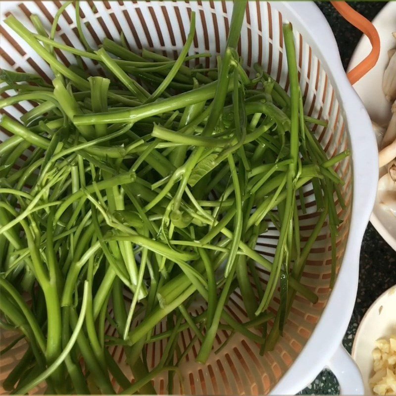 Rau muống tươi xanh đang được trụng sơ để giữ độ giòn