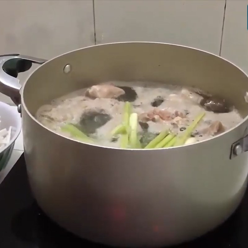 Rửa sạch xương heo sau khi chần giúp nước dùng bánh canh xương heo trong và ngon hơn