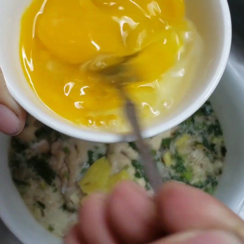 Rưới trứng đánh đều lên bề mặt óc bò đang hấp cho bé