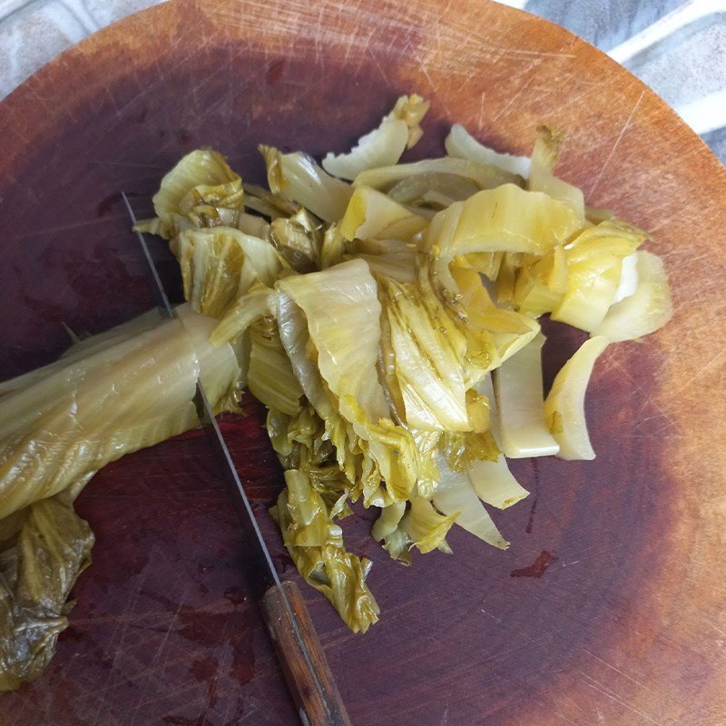 Sơ chế dưa cải chua bằng cách cắt miếng vừa ăn và vắt ráo nước.