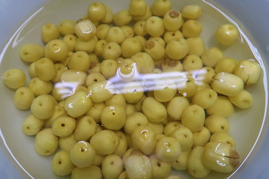 Sơ chế hạt sen tươi bằng cách ngâm nước ấm và loại bỏ tim sen để tránh vị đắng cho món sâm bổ lượng.