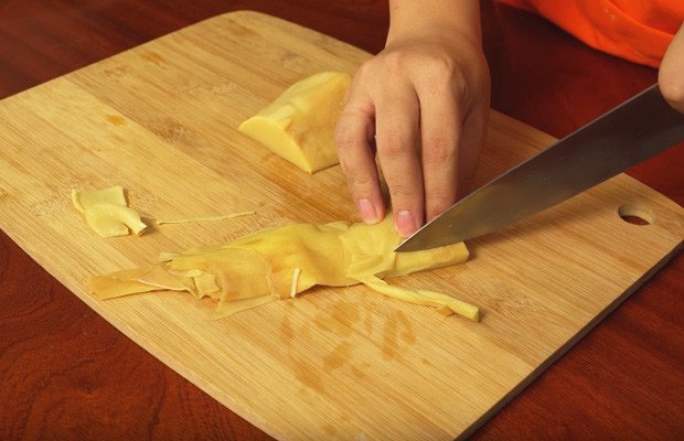 Sơ chế măng bằng cách cắt lát dài mỏng để chuẩn bị cho món bún măng chay