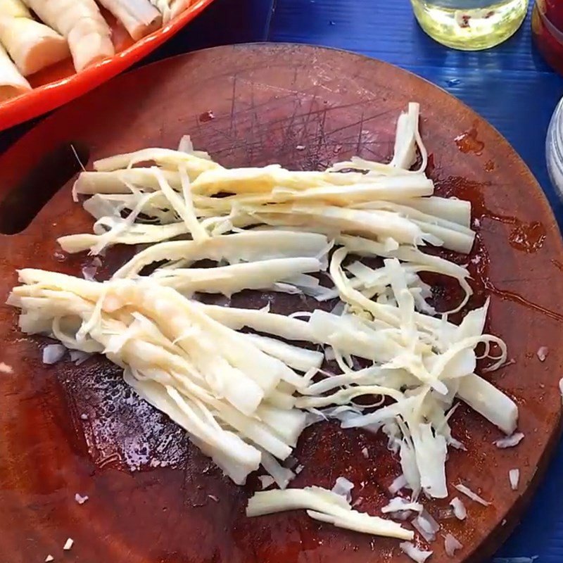 Sơ chế măng chua thành từng lát mỏng