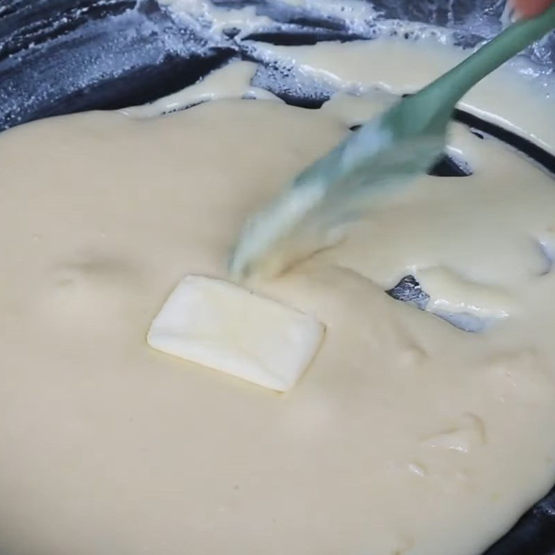 Sữa đang cô đặc dần trong chảo, chuẩn bị làm bánh sữa Ba Vì