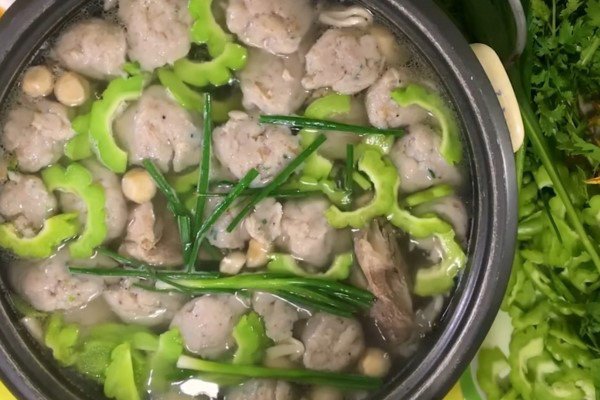 Thả chả cá và khổ qua vào nồi lẩu cá thác lác đang sôi