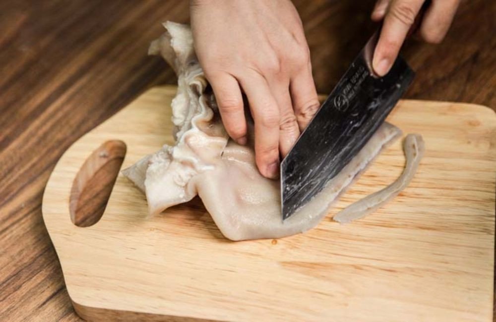 Thái tai heo thành sợi mỏng chuẩn bị làm gỏi ngó sen tôm thịt