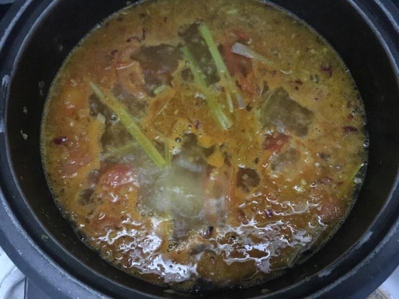 Thêm cà chua, thơm và gói gia vị lẩu Thái vào nồi nước dùng