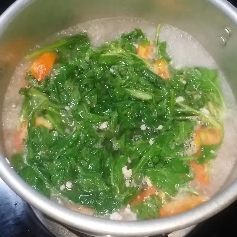 Thêm cải cúc vào nồi canh chay đang sôi