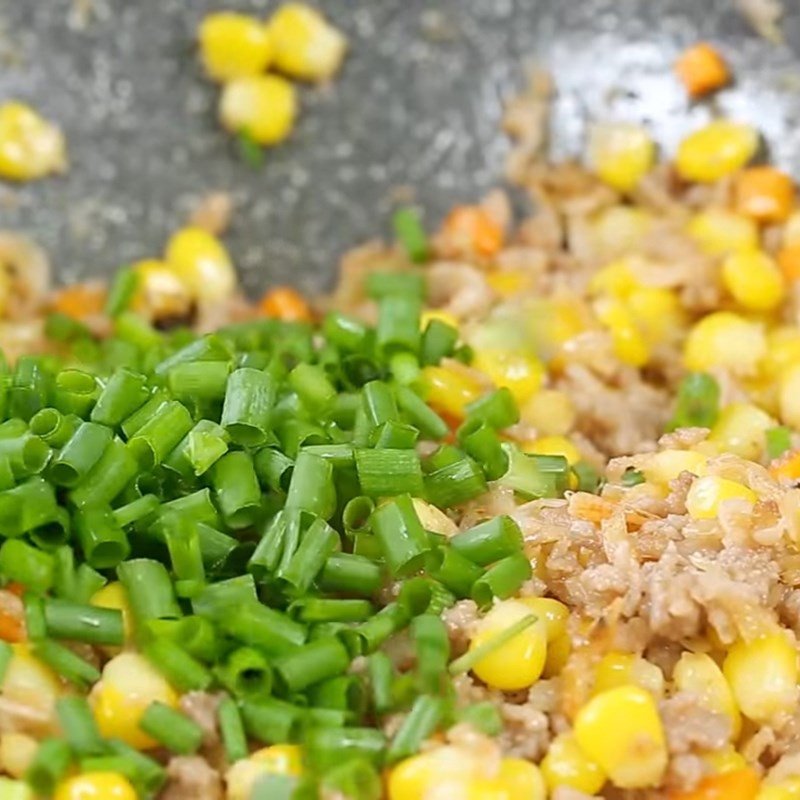Thêm hành lá vào món ngô ngọt xào thịt băm cuối cùng