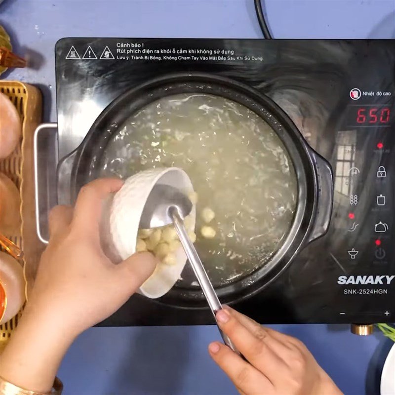 Thêm hạt sen tươi vào nồi cháo đang sôi để hạt sen mềm và cháo thêm dinh dưỡng