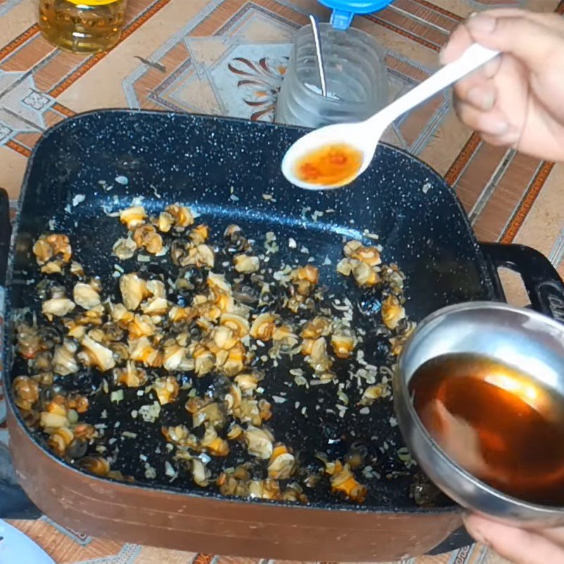 Thêm lá lốt và tía tô vào chảo ốc đang xào, đảo đều cho thấm hương