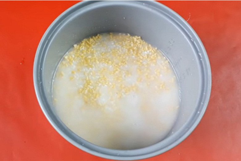 Thêm nước cốt dừa và nước vào gạo nếp đậu xanh trong nồi cơm điện