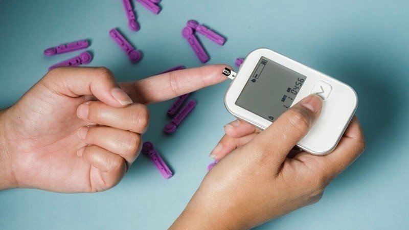 Thiết bị đo đường huyết và cà rốt, minh họa vai trò của cà rốt trong việc quản lý bệnh tiểu đường và ổn định đường huyết.