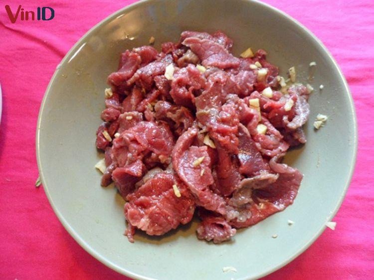 Thịt bò đã thái lát được ướp gia vị đậm đà để chuẩn bị xào tỏi