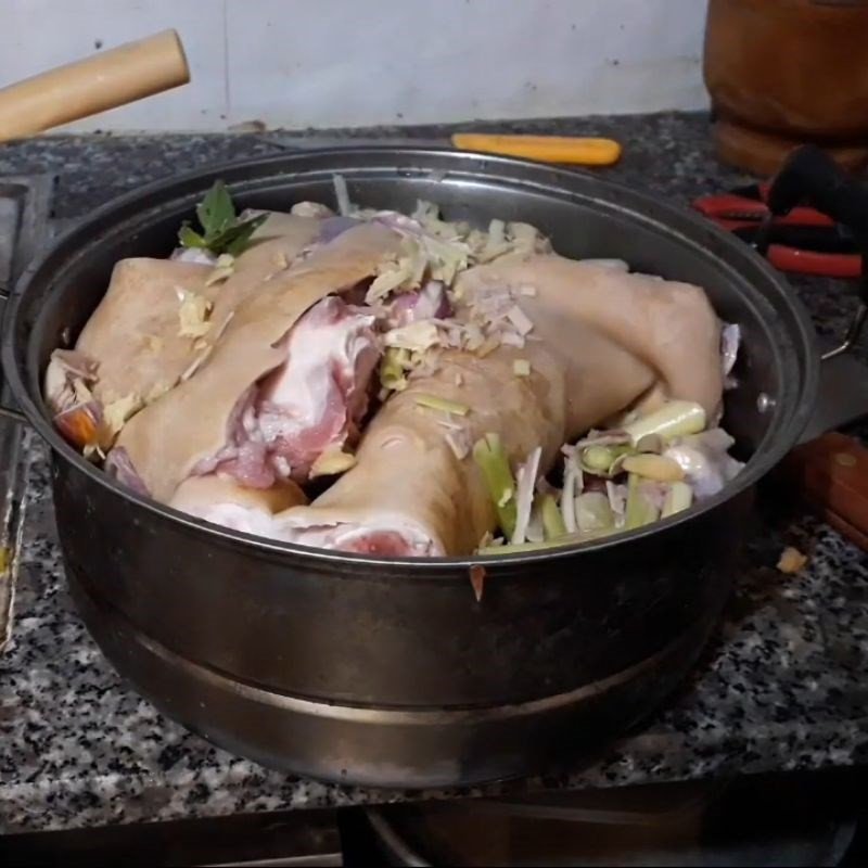 Thịt dê đang được tẩm ướp cùng tỏi, hành tím và sả nhét vào các vết khía, chuẩn bị cho món thịt dê hấp sả.