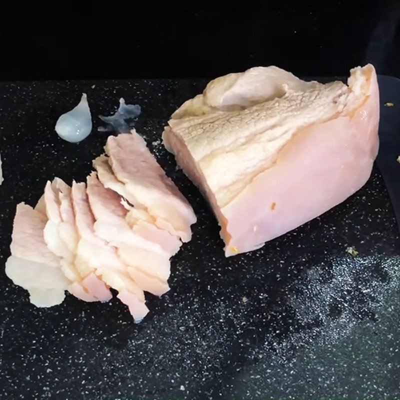 Thịt heo ba chỉ đã luộc chín, thái lát mỏng đều sẵn sàng cho việc cuộn bánh tráng thập cẩm
