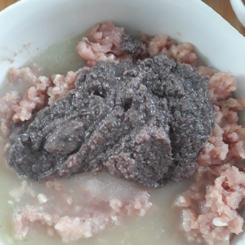 Thịt heo băm đang được trộn đều với mắm ruốc, đường, hạt nêm và nước cốt riềng để ướp