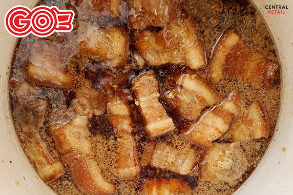 Thịt kho trứng đang được om trên bếp với nước dừa tươi
