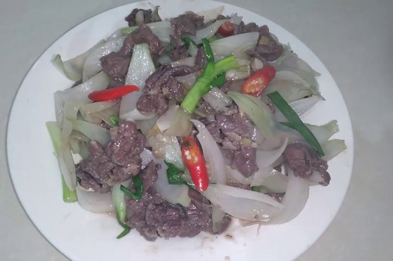 Thịt ngựa và hành tây đang được xào nhanh trên chảo nóng hổi