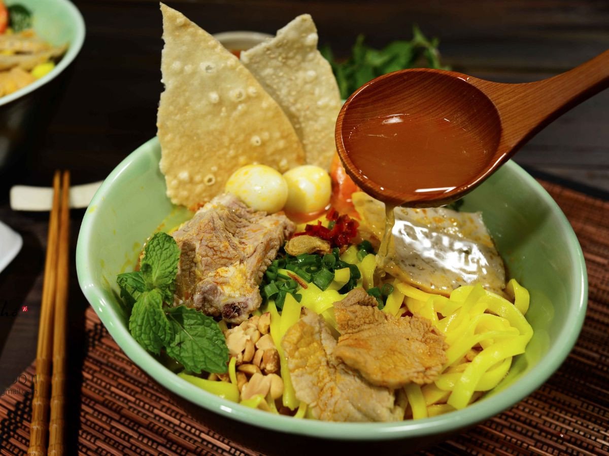 Tô mì Quảng gà Quảng Nam hoàn chỉnh với sợi mì, thịt gà, rau sống và chén nước mắm ớt.