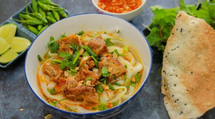 Tô mì Quảng sườn đầy đặn với sợi mì vàng, sườn non, tôm, trứng cút và rau sống đặc trưng, gợi nhớ hương vị ẩm thực miền Trung Việt Nam.