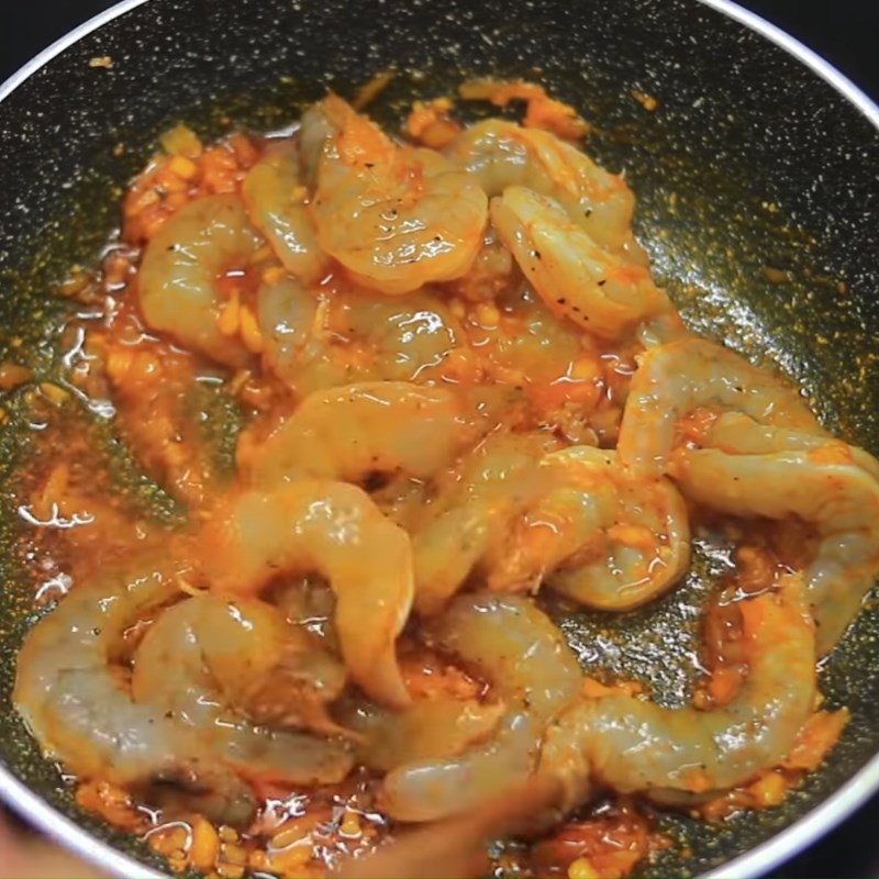 Tôm và trứng được xào nhanh trên chảo với dầu điều