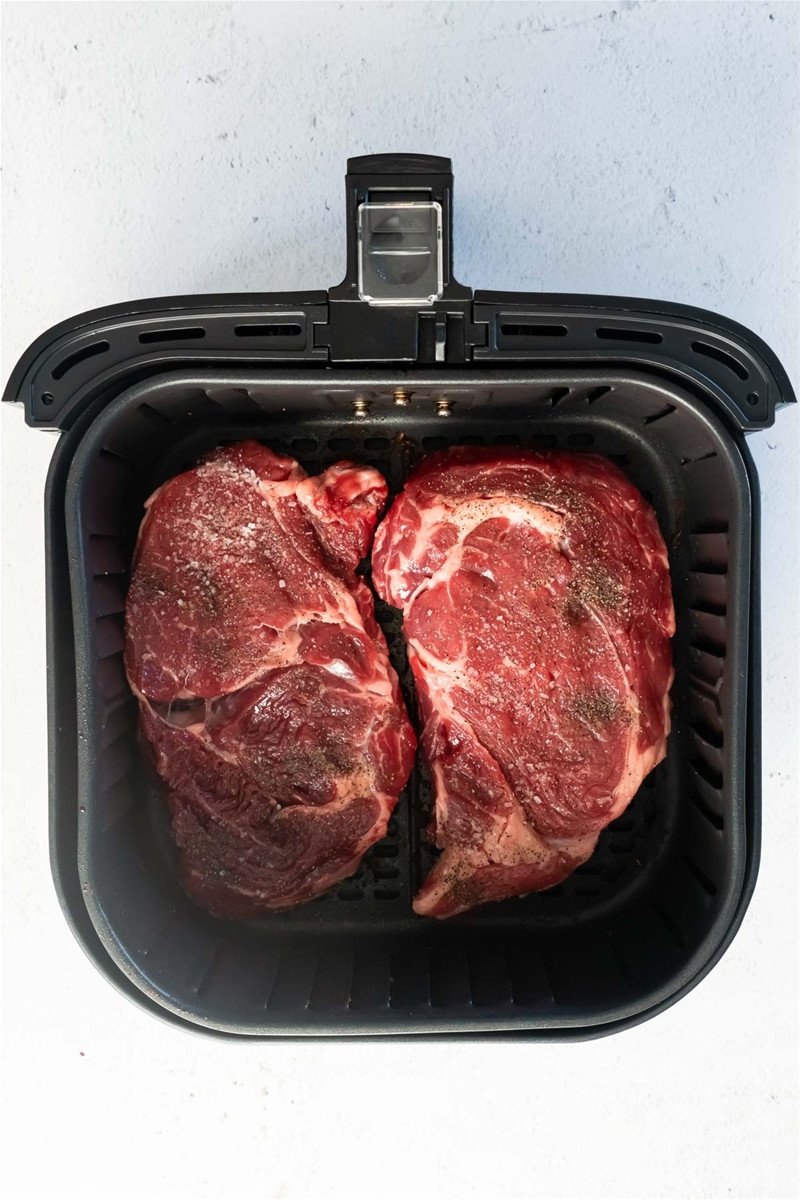 Trải đều hai miếng thịt bò đã tẩm ướp gia vị vào nồi chiên