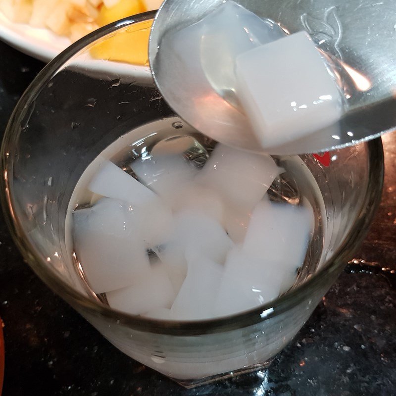 Trình bày các lớp thạch dừa, bột khoai, hạt chia và trái cây vào ly