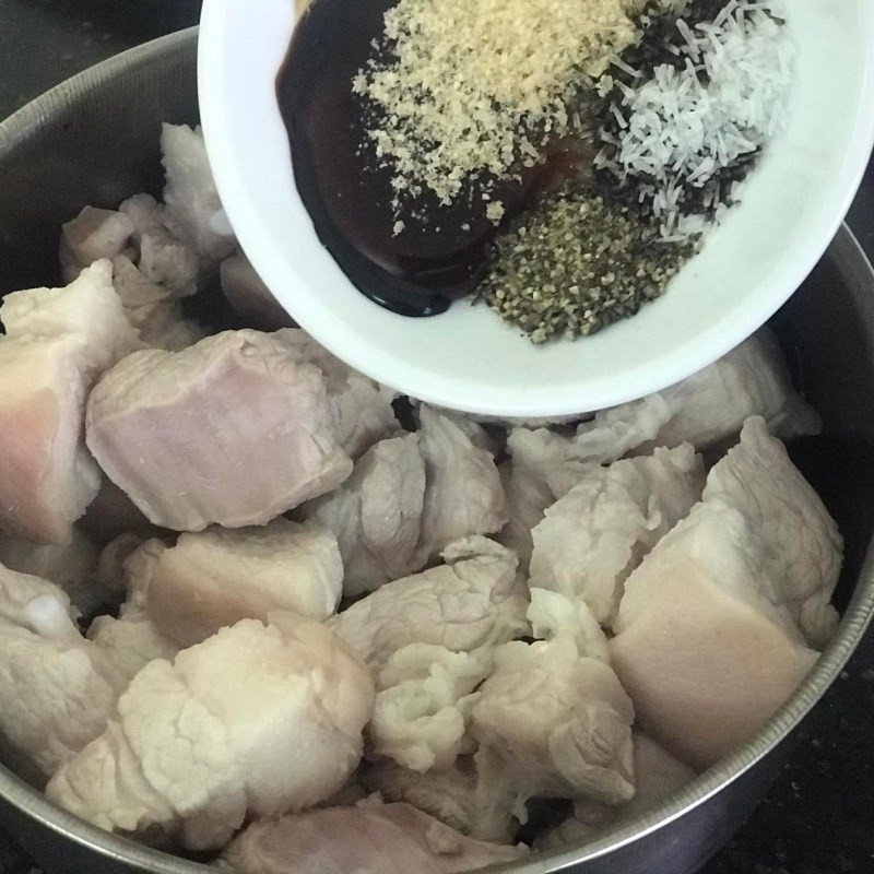 Trộn đều gia vị với thịt ba chỉ để ướp cho món thịt kho trám xanh