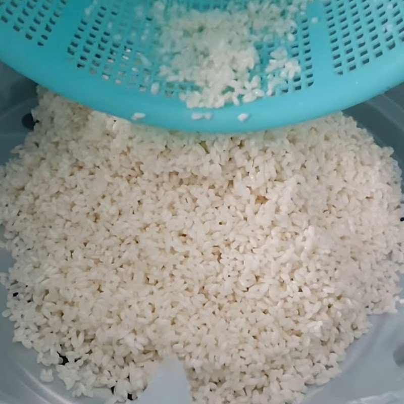 Trộn đều nếp với nước cốt dừa hoa đậu biếc sau khi hấp sơ, giúp xôi ngấm đều hương vị