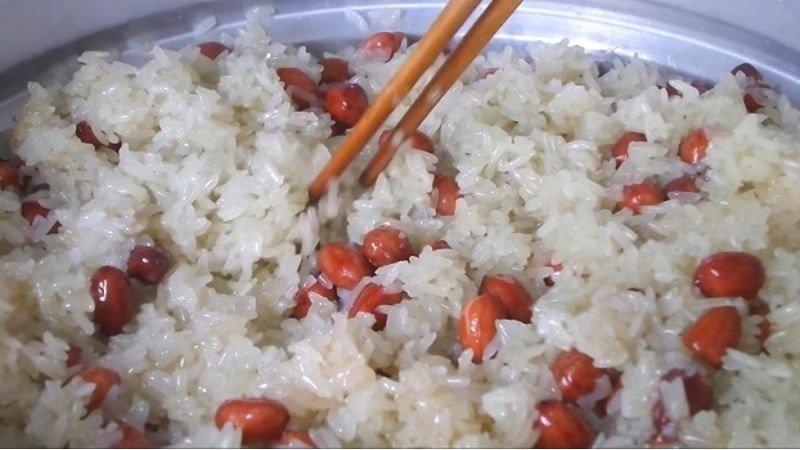Trộn đều xôi đậu phộng trong nồi cơm điện để xôi chín đều và thơm ngon