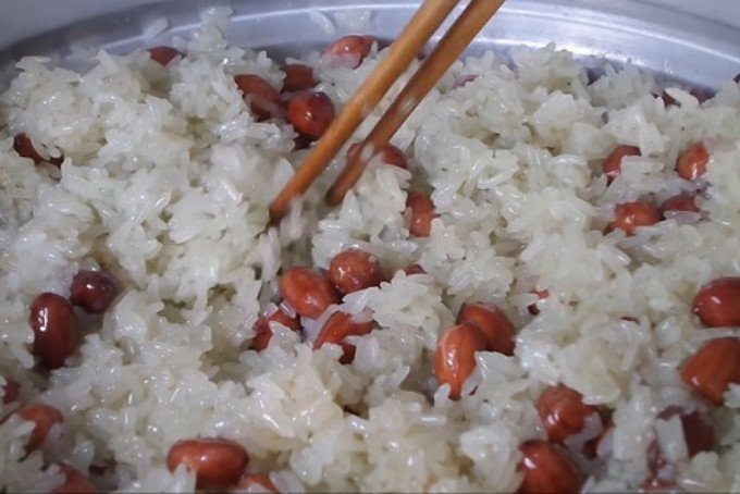 Trộn đều xôi lạc với nước cốt dừa và dừa sợi trong xửng hấp