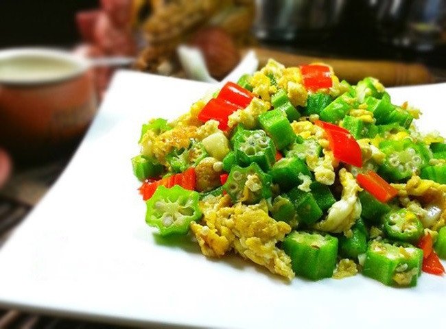 Trứng gà đang được chiên vàng trong chảo để kết hợp cùng đậu bắp xào không nhớt