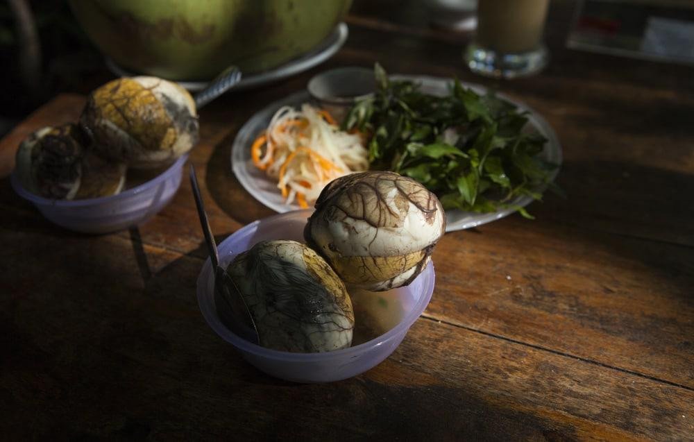 Trứng vịt lộn nóng hổi ăn kèm rau răm và gừng, một sự kết hợp hoàn hảo