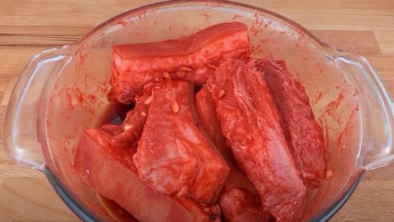 Ướp thịt heo với gia vị để ngấm đều trước khi khìa