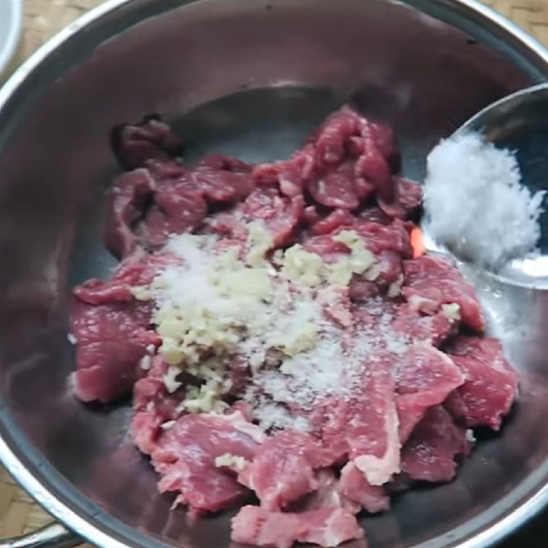 Ướp thịt trâu với gia vị và tỏi băm