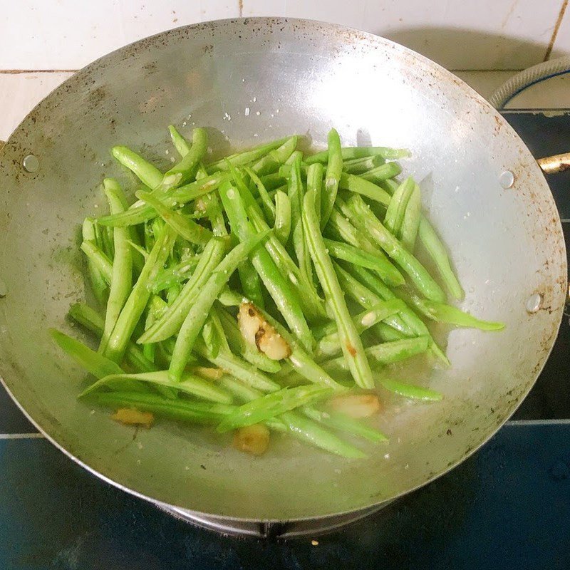 Xào đậu ve cùng gia vị trên chảo lửa lớn