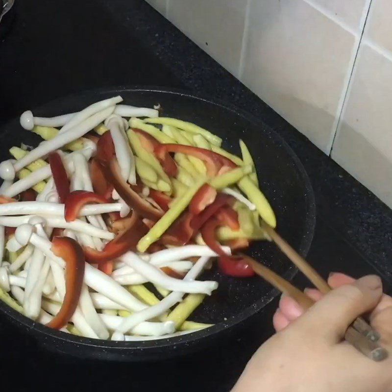 Xào hỗn hợp ngô bao tử, ớt chuông và nấm trên bếp, tạo nên món xào ngon miệng