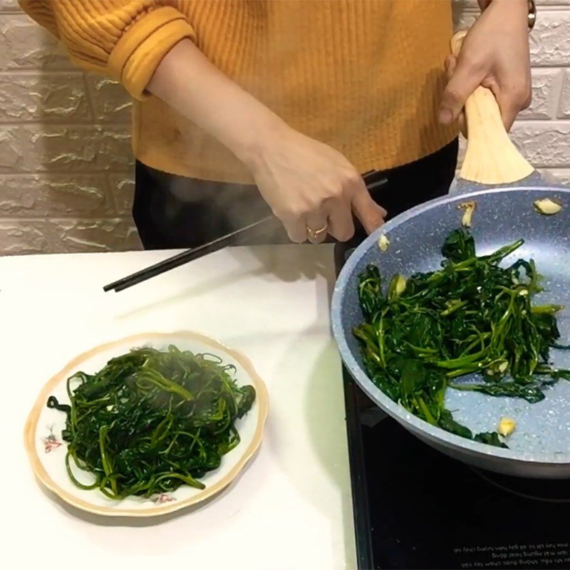 Xào rau lang cùng tỏi phi thơm trên chảo lửa lớn