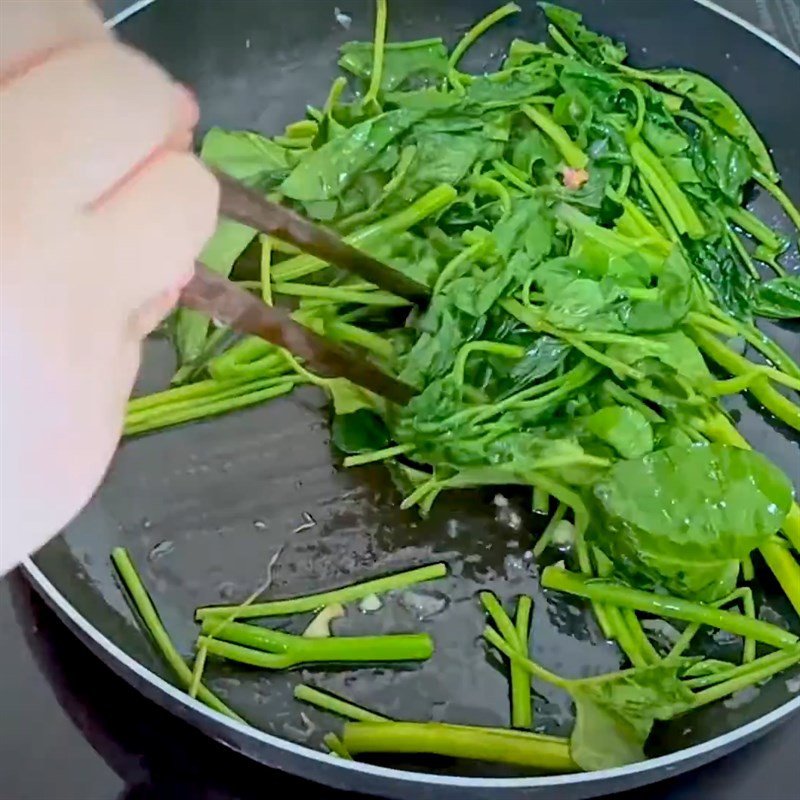 Xào rau muống trước khi cho ốc móng tay và mì vào