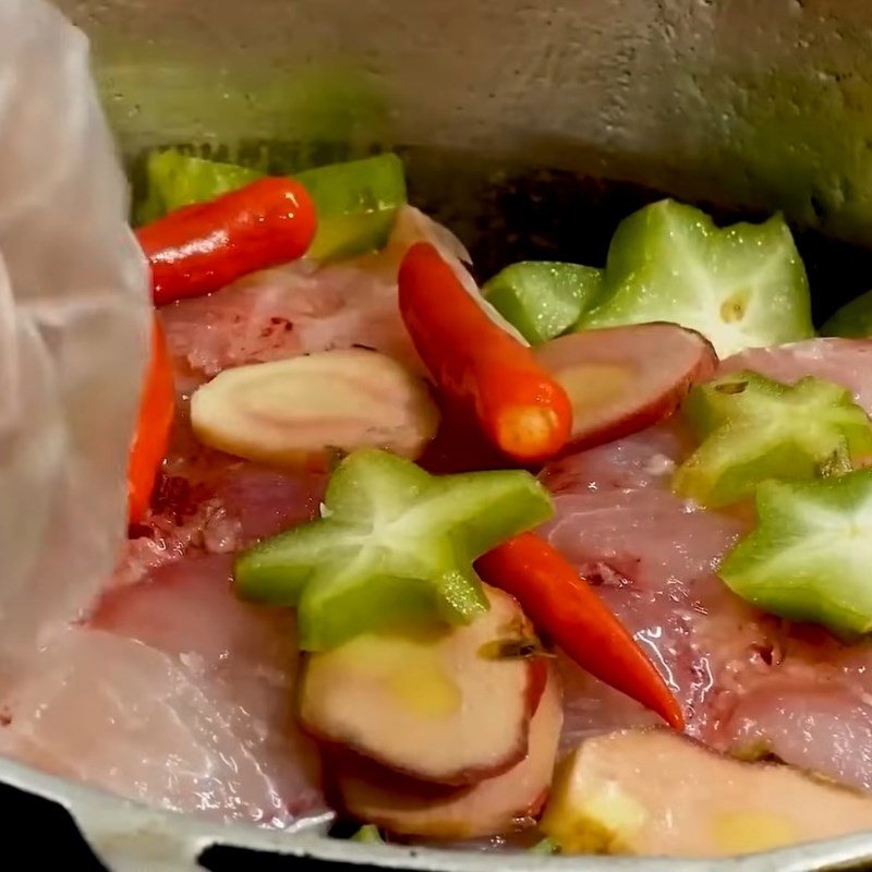 Xếp từng khúc cá trắm đen đã ướp vào nồi để kho riềng