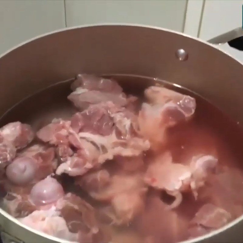 Xương heo đang được sơ chế bằng cách luộc qua để loại bỏ tạp chất, bước quan trọng trong cách nấu bánh canh xương heo